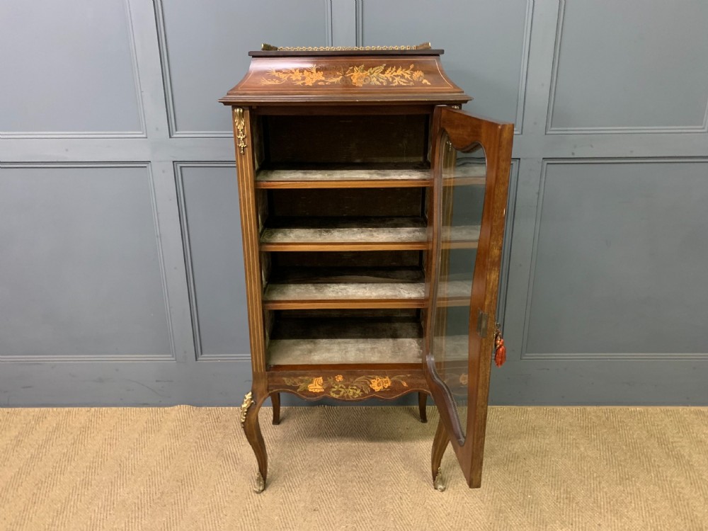 A freestanding mahogany vitrine featuring floral marquetry, a single glazed door, a brass top gallery, and cabriole legs with metal mounts. View XVIII