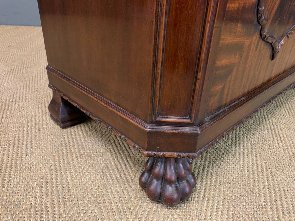 A tall mahogany Chippendale style glazed bookcase featuring three astragal glazed upper doors above three carved panelled lower cupboard doors resting on ball and claw feet. View VI