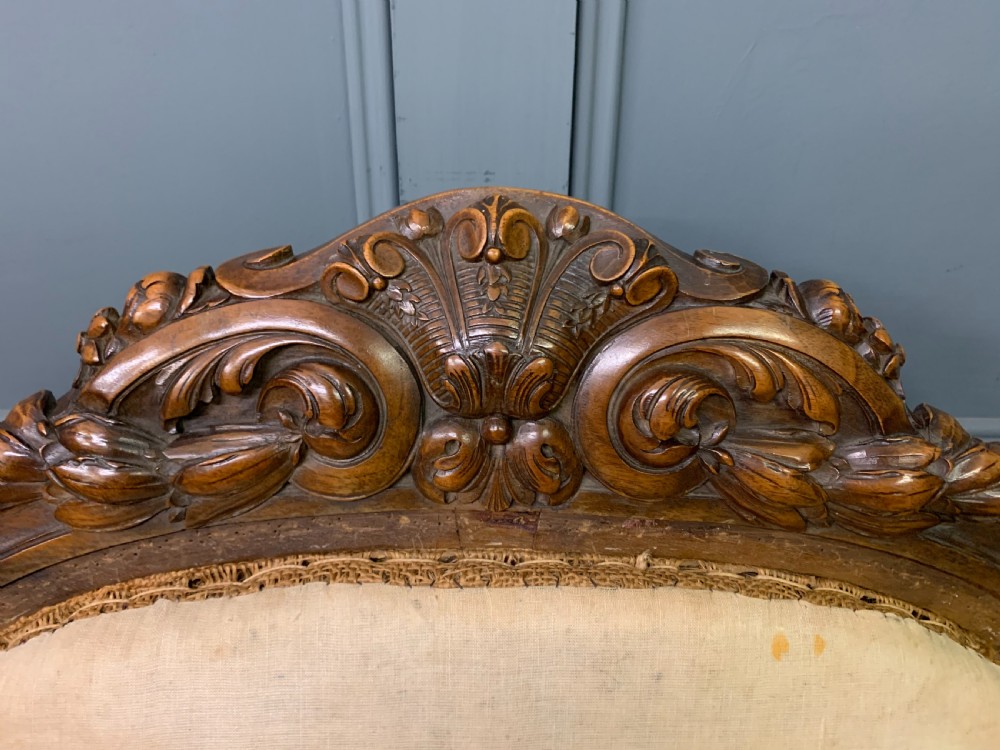 A pair of antique carved walnut French fauteuil armchairs featuring cream fabric upholstery and cabriole legs. View VII