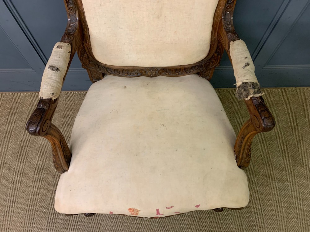 A pair of antique carved walnut French fauteuil armchairs featuring cream fabric upholstery and cabriole legs. View IX
