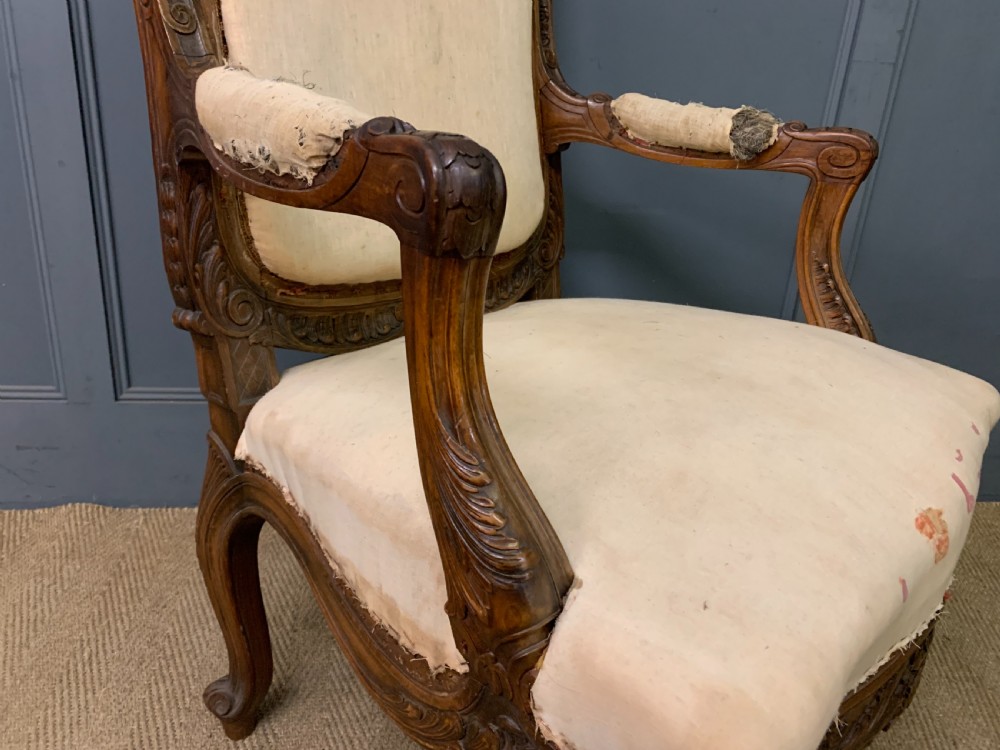 A pair of antique carved walnut French fauteuil armchairs featuring cream fabric upholstery and cabriole legs. View XIII