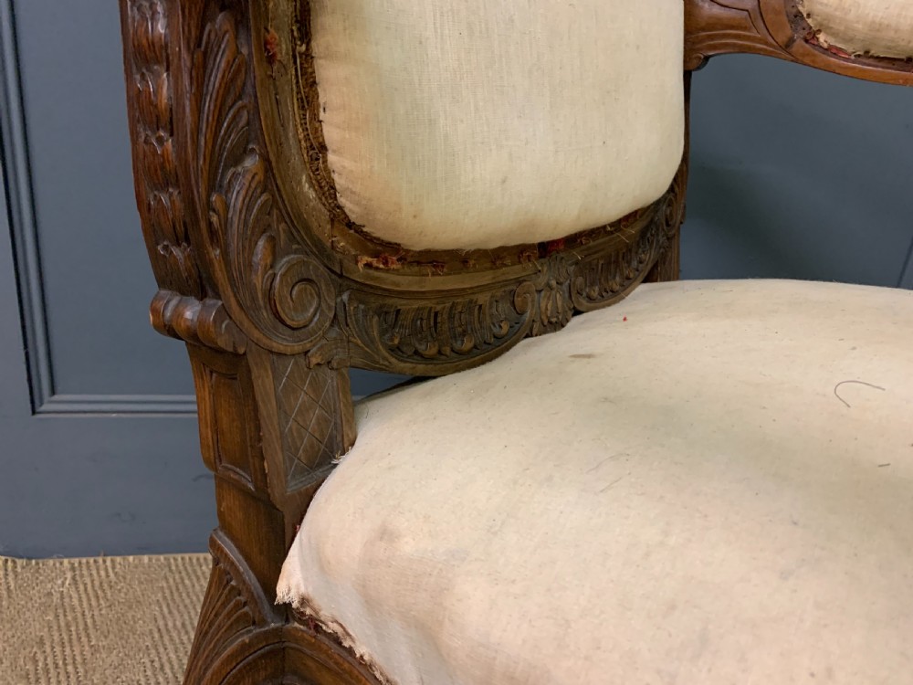 A pair of antique carved walnut French fauteuil armchairs featuring cream fabric upholstery and cabriole legs. View XV