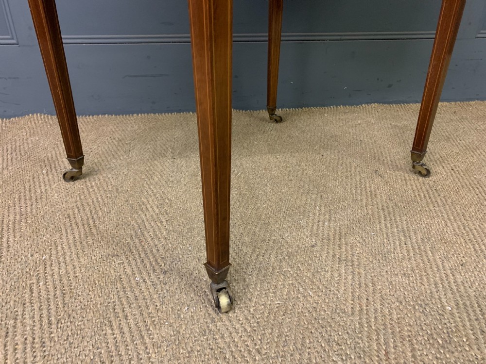 An Edwardian kidney-shaped mahogany table with central marquetry inlay, a single drawer with brass handles, and four tapered legs on castors. View XI