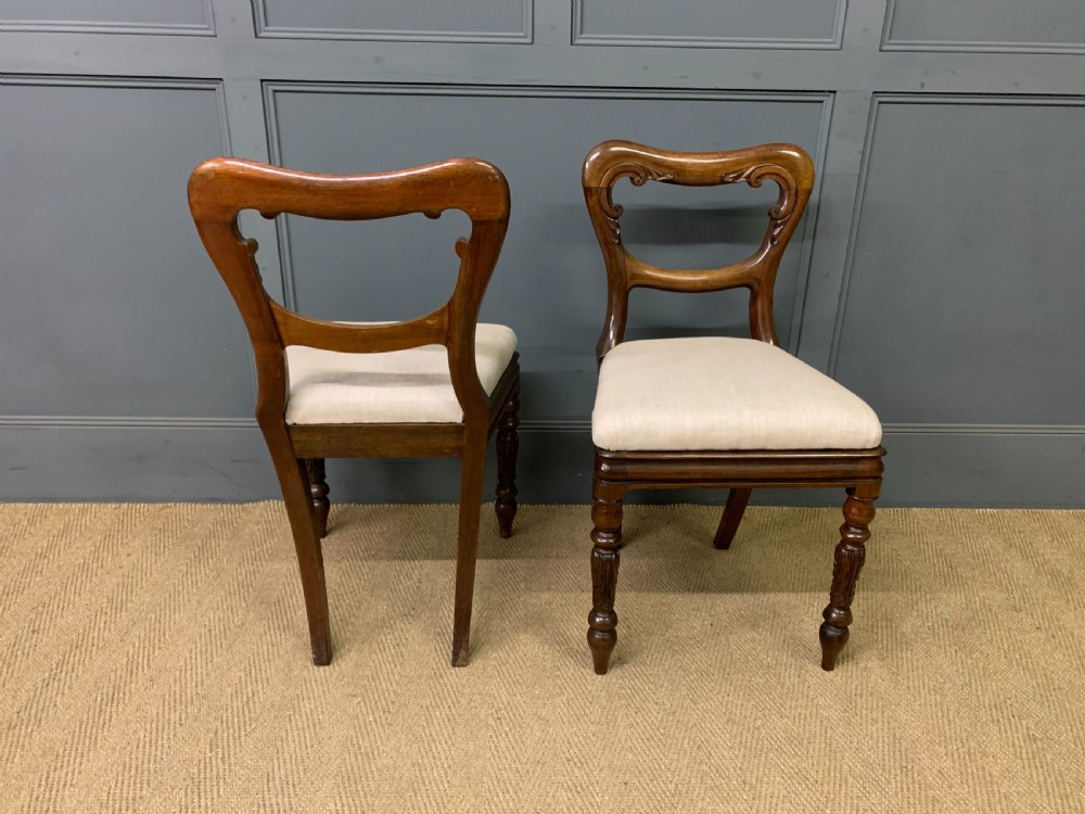 A set of eight early Victorian rosewood dining chairs featuring rounded balloon back frames, carved rail detailing, turned legs, and neutral upholstered seats. View VII