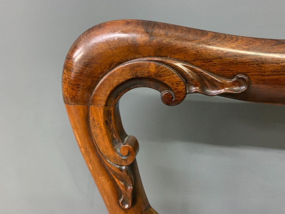 A set of eight early Victorian rosewood dining chairs featuring rounded balloon back frames, carved rail detailing, turned legs, and neutral upholstered seats. View XI