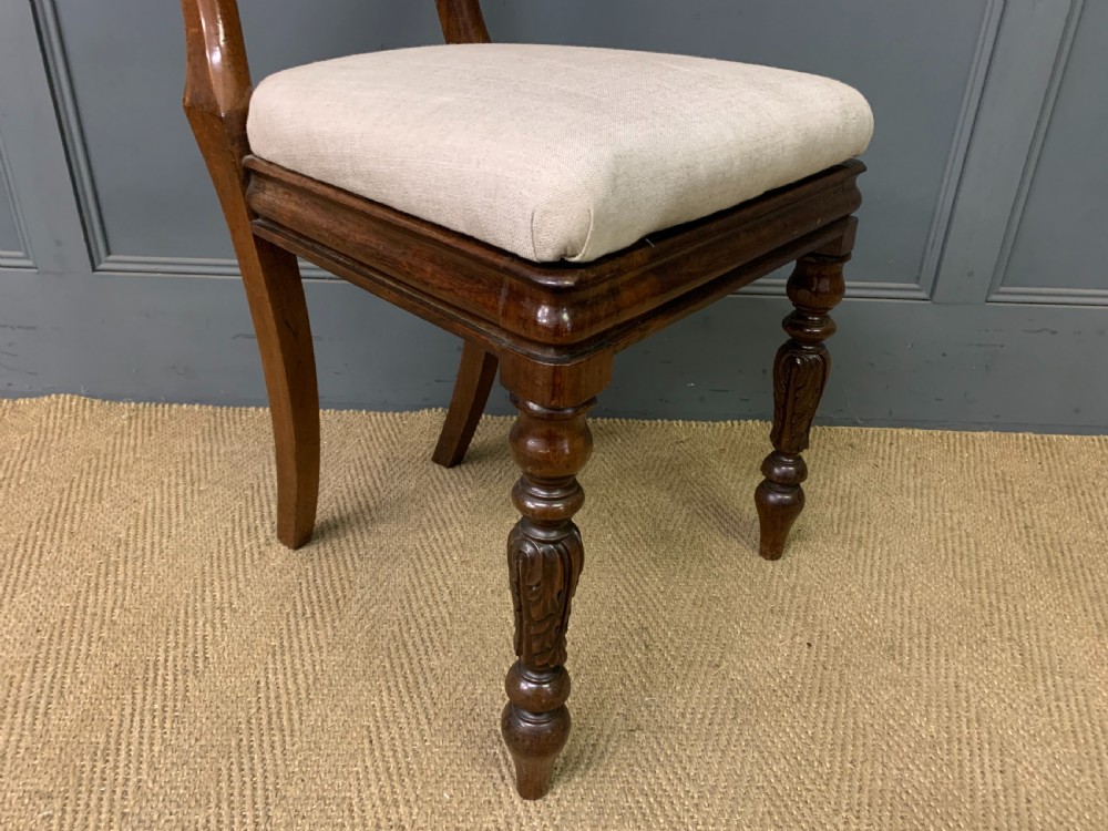 A set of eight early Victorian rosewood dining chairs featuring rounded balloon back frames, carved rail detailing, turned legs, and neutral upholstered seats. View XIII