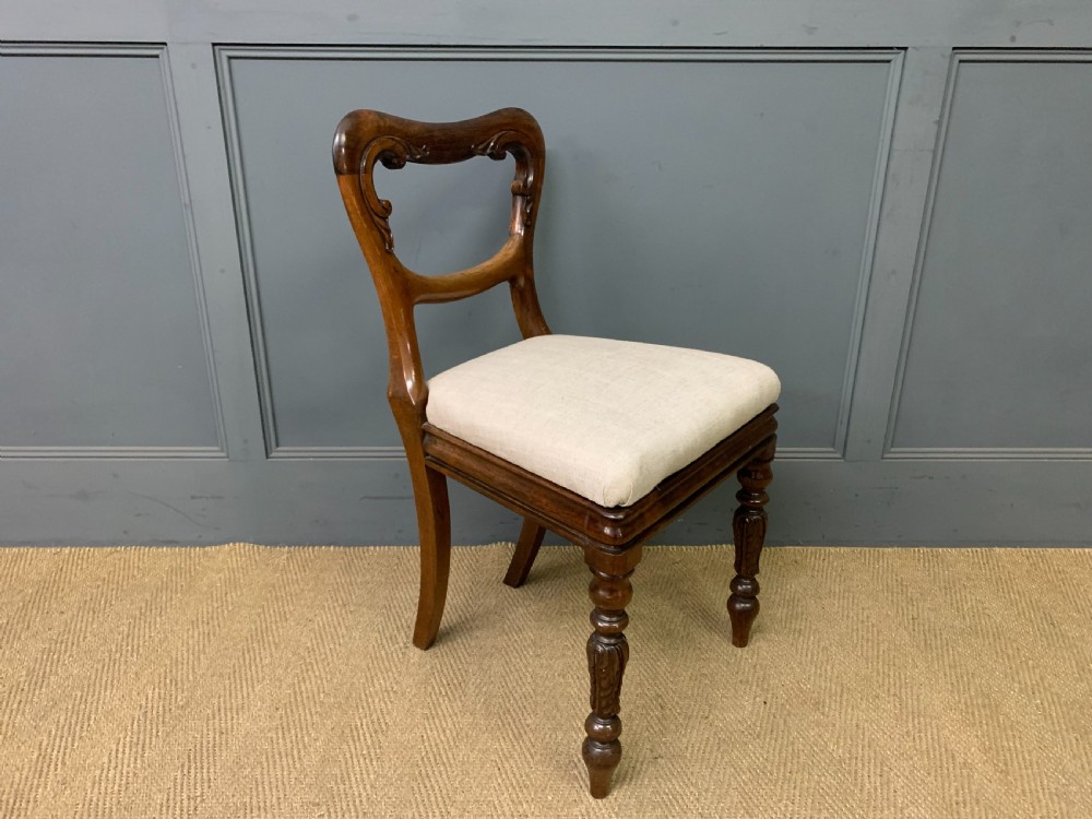 A set of eight early Victorian rosewood dining chairs featuring rounded balloon back frames, carved rail detailing, turned legs, and neutral upholstered seats. View XIV