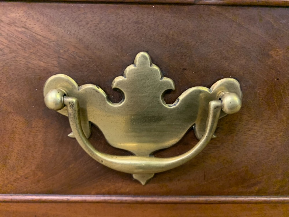 A Georgian mahogany bachelor chest featuring multiple drawers, brass handles, bracket feet, and an extended writing slide lined with green baize. View IX