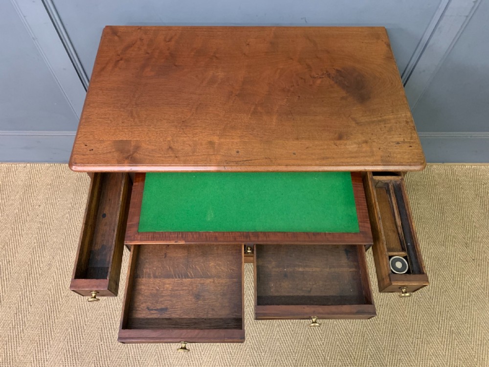 A Georgian mahogany bachelor chest featuring multiple drawers, brass handles, bracket feet, and an extended writing slide lined with green baize. View XII