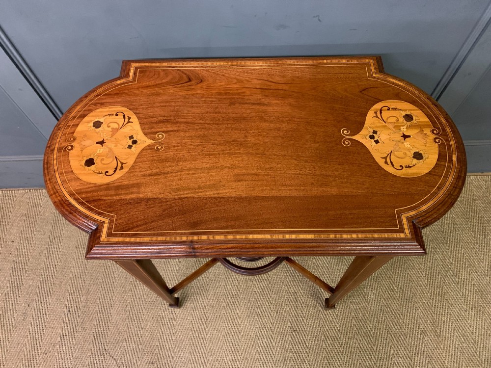 An Edwardian mahogany occasional table featuring intricate floral marquetry top inlays, tapered legs, and a central circular spindled undertier. View III