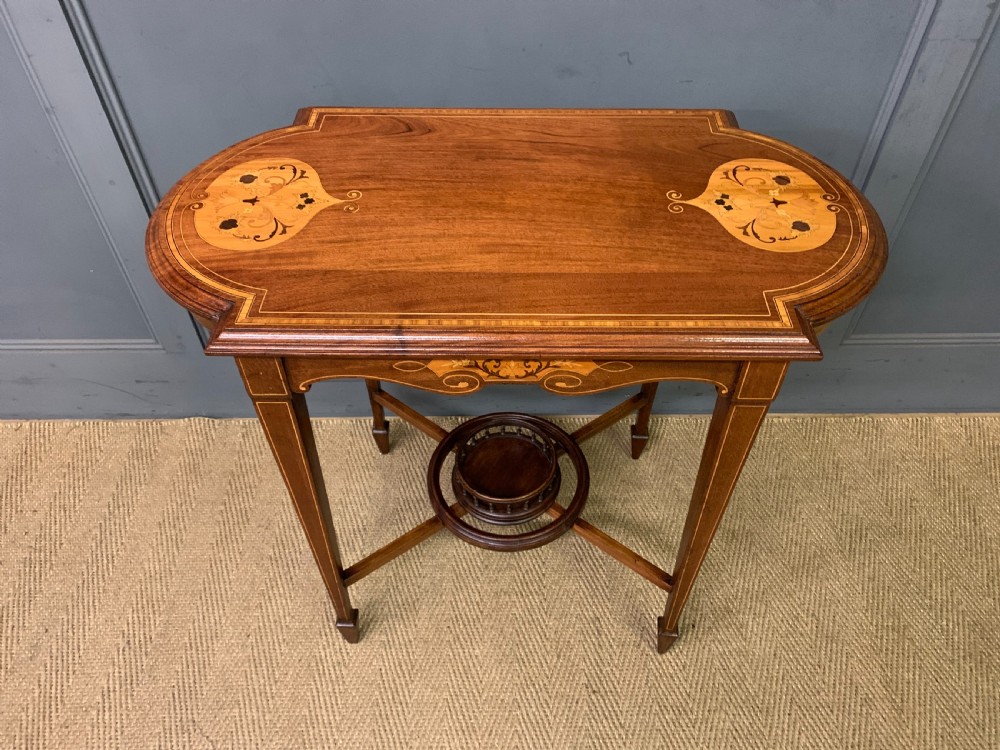 An Edwardian mahogany occasional table featuring intricate floral marquetry top inlays, tapered legs, and a central circular spindled undertier. View V