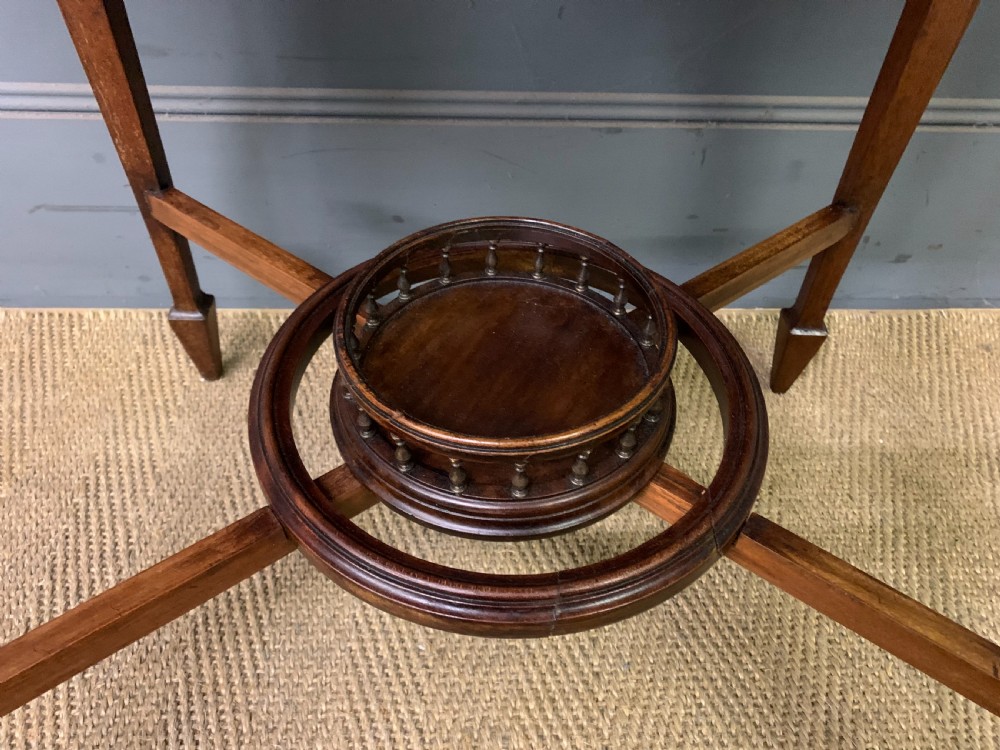 An Edwardian mahogany occasional table featuring intricate floral marquetry top inlays, tapered legs, and a central circular spindled undertier. View VI