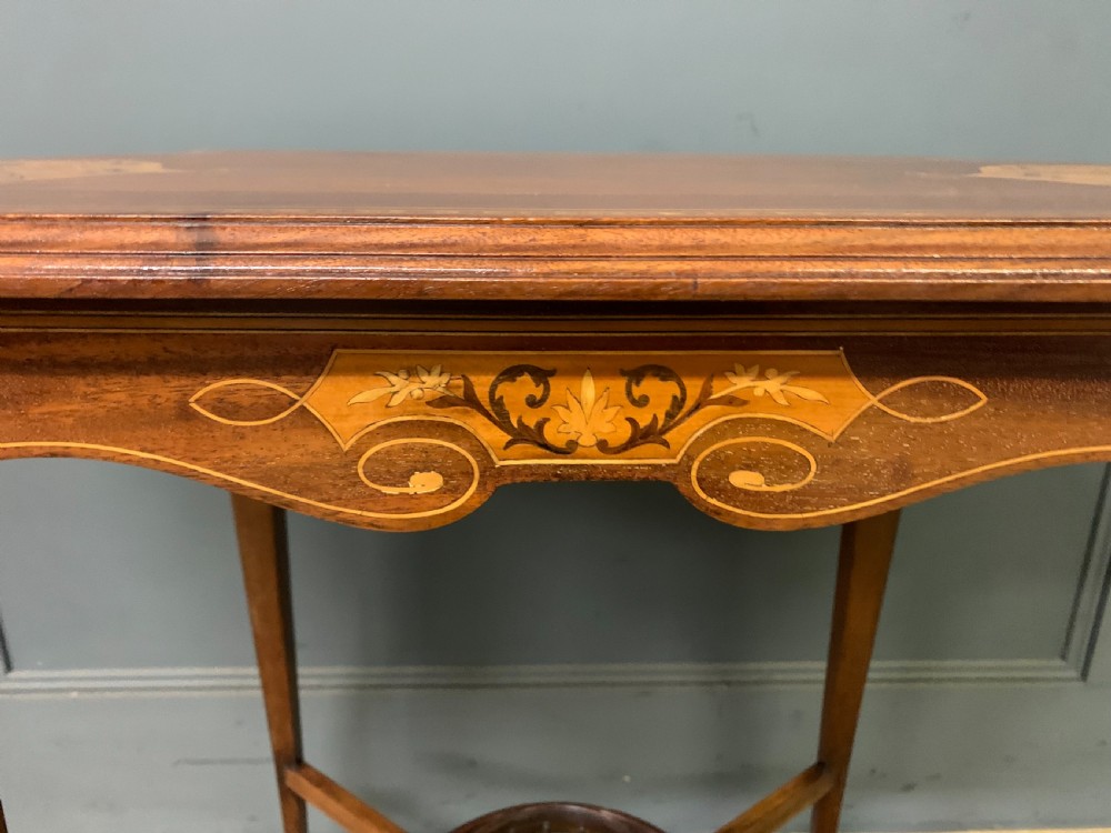An Edwardian mahogany occasional table featuring intricate floral marquetry top inlays, tapered legs, and a central circular spindled undertier. View VII