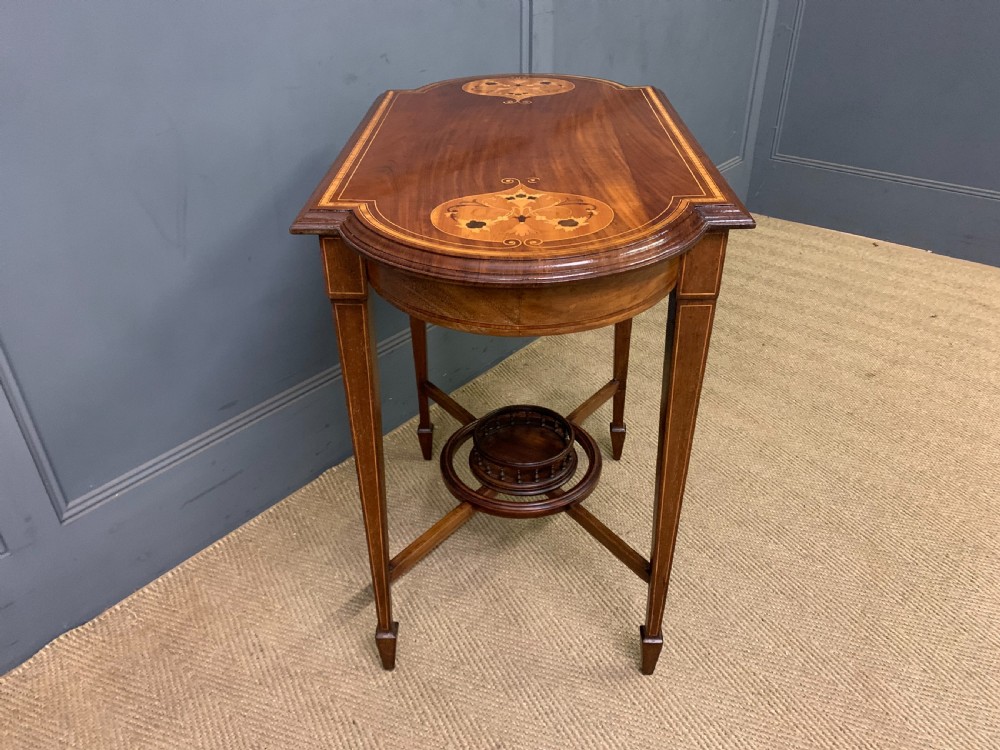 An Edwardian mahogany occasional table featuring intricate floral marquetry top inlays, tapered legs, and a central circular spindled undertier. View IX