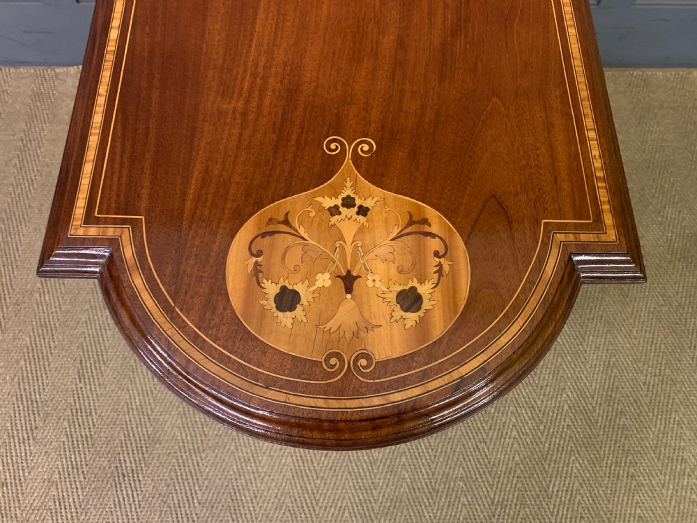 An Edwardian mahogany occasional table featuring intricate floral marquetry top inlays, tapered legs, and a central circular spindled undertier. View XI
