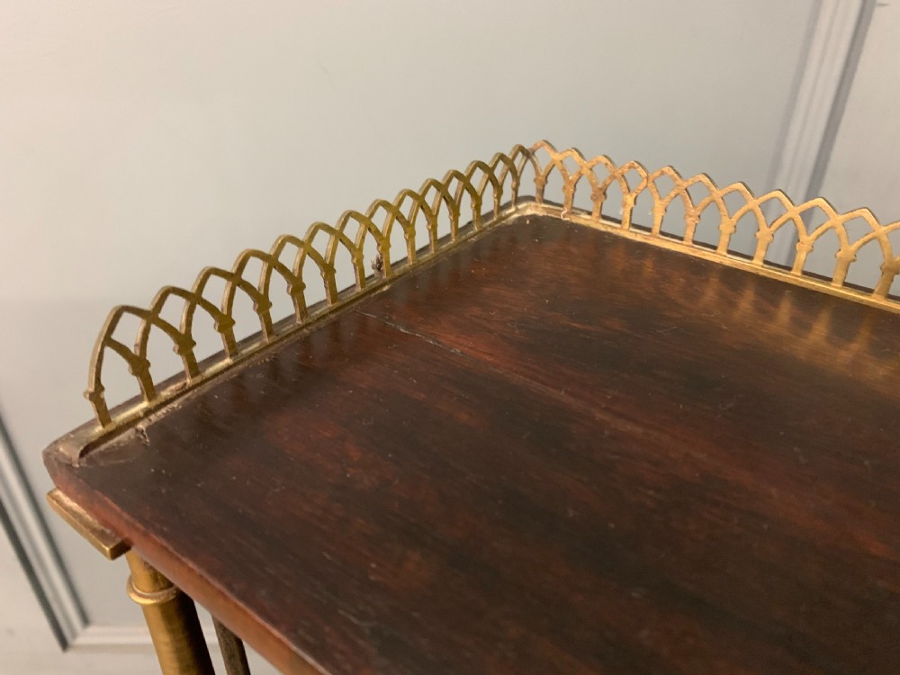 An antique Regency rosewood chiffonier featuring a brass lattice gallery shelf, two upper drawers, and lower doors with wire mesh and pleated fabric panels. View XXIII