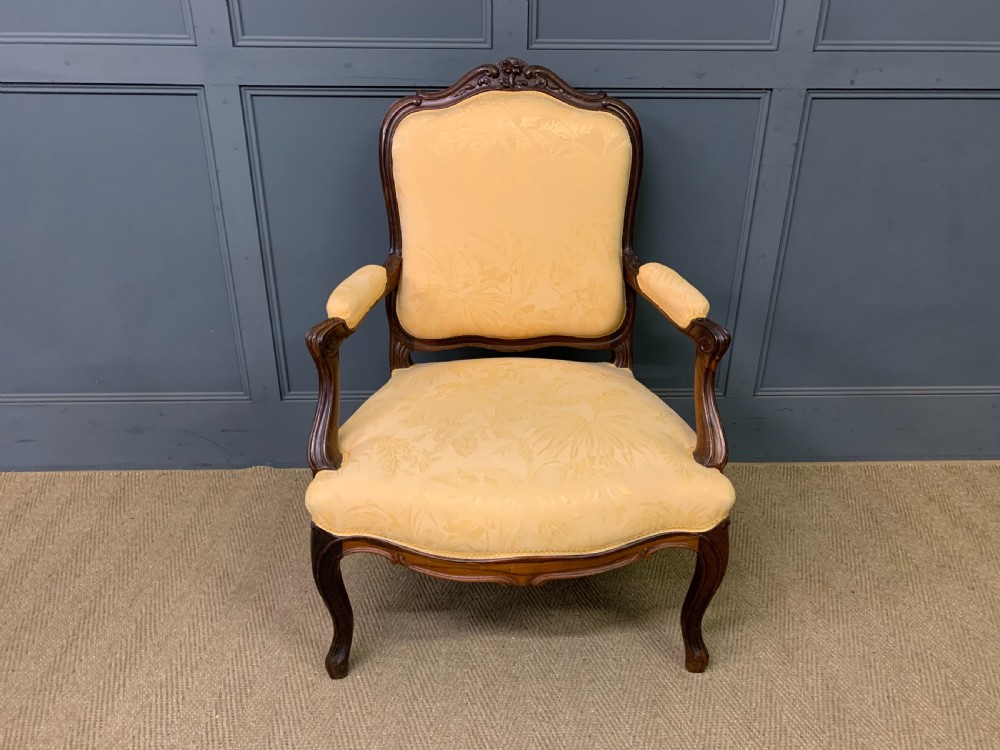A pair of antique French rosewood fauteuil armchairs with carved serpentine frames, cabriole legs, and yellow floral damask upholstery. View VIII