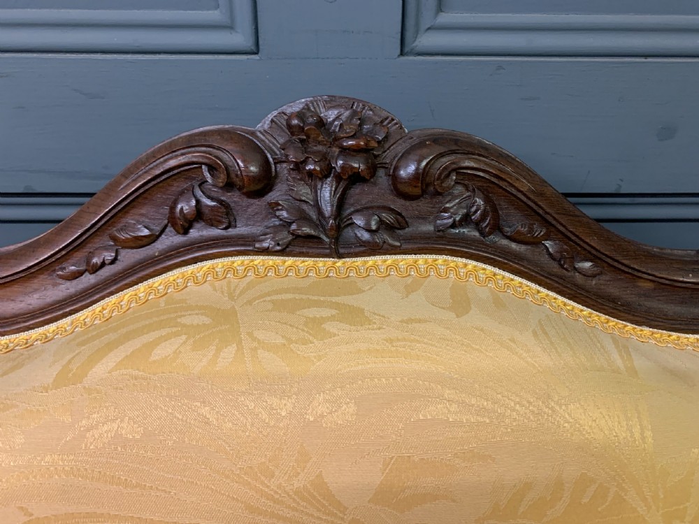 A pair of antique French rosewood fauteuil armchairs with carved serpentine frames, cabriole legs, and yellow floral damask upholstery. View XI