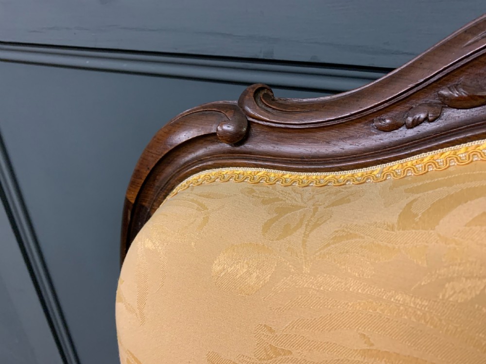 A pair of antique French rosewood fauteuil armchairs with carved serpentine frames, cabriole legs, and yellow floral damask upholstery. View XII