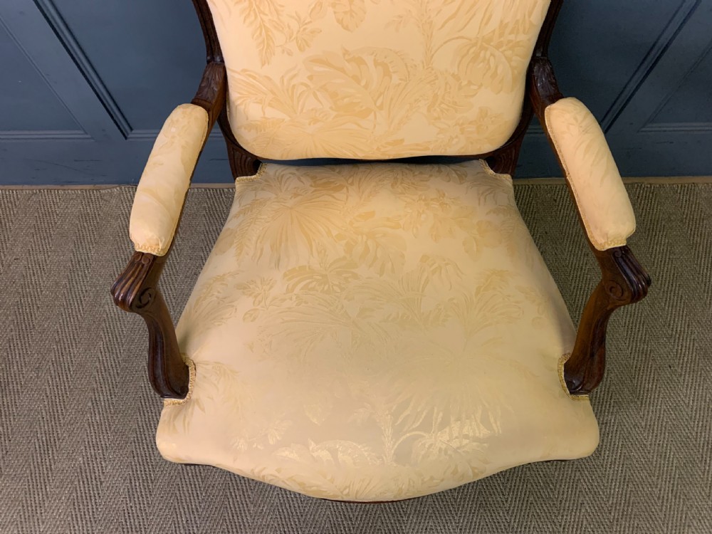 A pair of antique French rosewood fauteuil armchairs with carved serpentine frames, cabriole legs, and yellow floral damask upholstery. View XIII