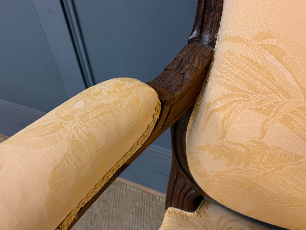 A pair of antique French rosewood fauteuil armchairs with carved serpentine frames, cabriole legs, and yellow floral damask upholstery. View XIV