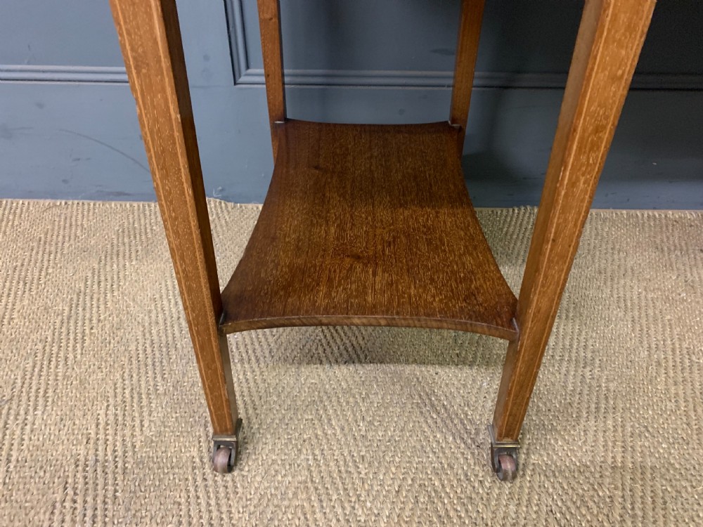 An Edwardian mahogany writing desk featuring a green leather surface, brass gallery rail, marquetry sloped panels, and drawer pedestals on tapered legs. View XI