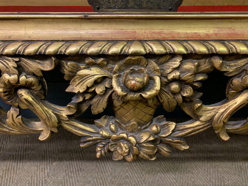A bright red lacquered Chinoiserie cabinet with gold hand-painted figures and landscapes, mounted on an ornate carved giltwood stand with cabriole legs. View XI