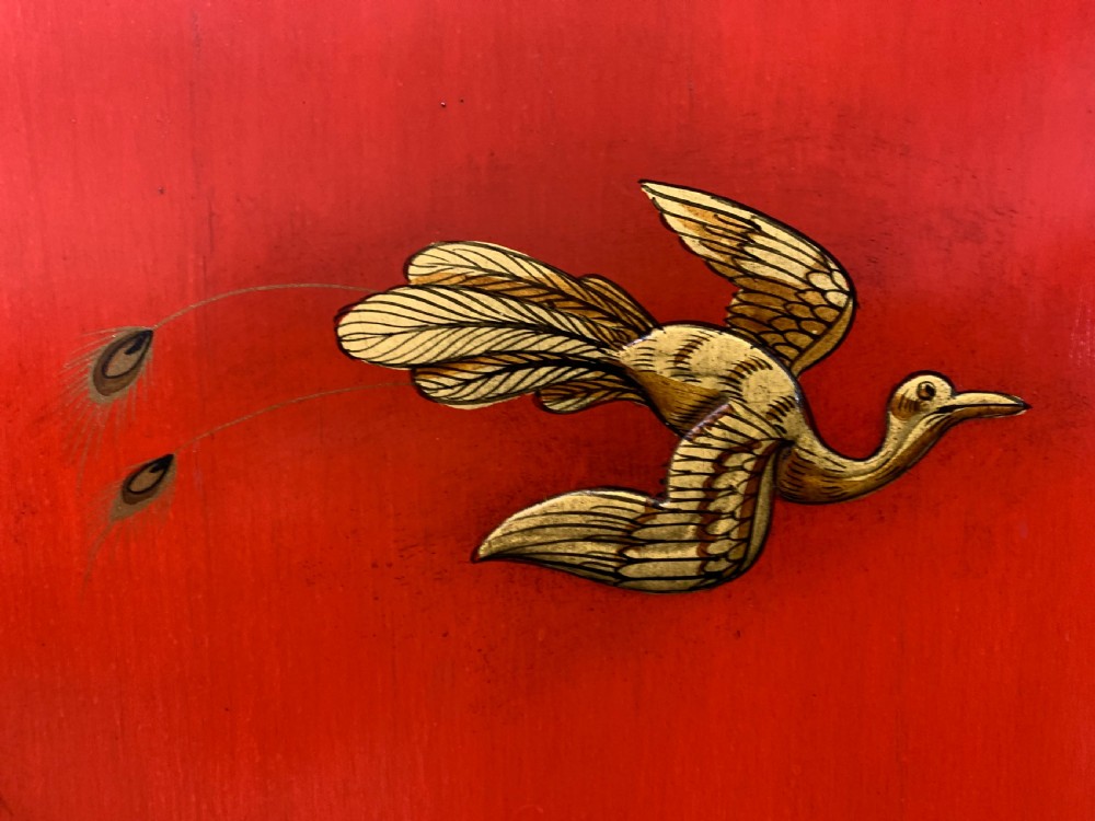 A bright red lacquered Chinoiserie cabinet with gold hand-painted figures and landscapes, mounted on an ornate carved giltwood stand with cabriole legs. View XII