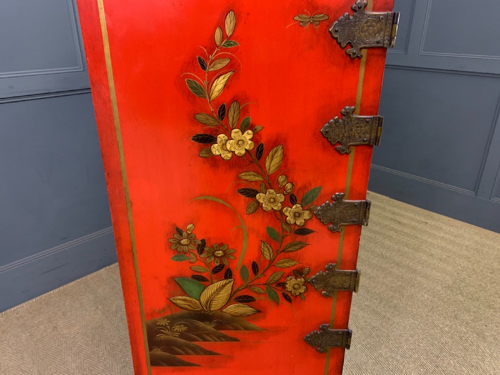 A bright red lacquered Chinoiserie cabinet with gold hand-painted figures and landscapes, mounted on an ornate carved giltwood stand with cabriole legs. View XX