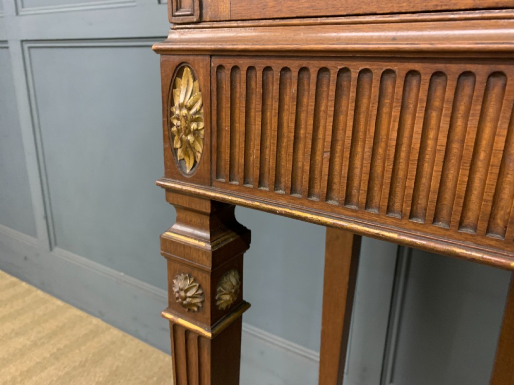 An antique mahogany display cabinet featuring glazed centre doors, side inlaid panels, fluted legs, and an arched top. View VII