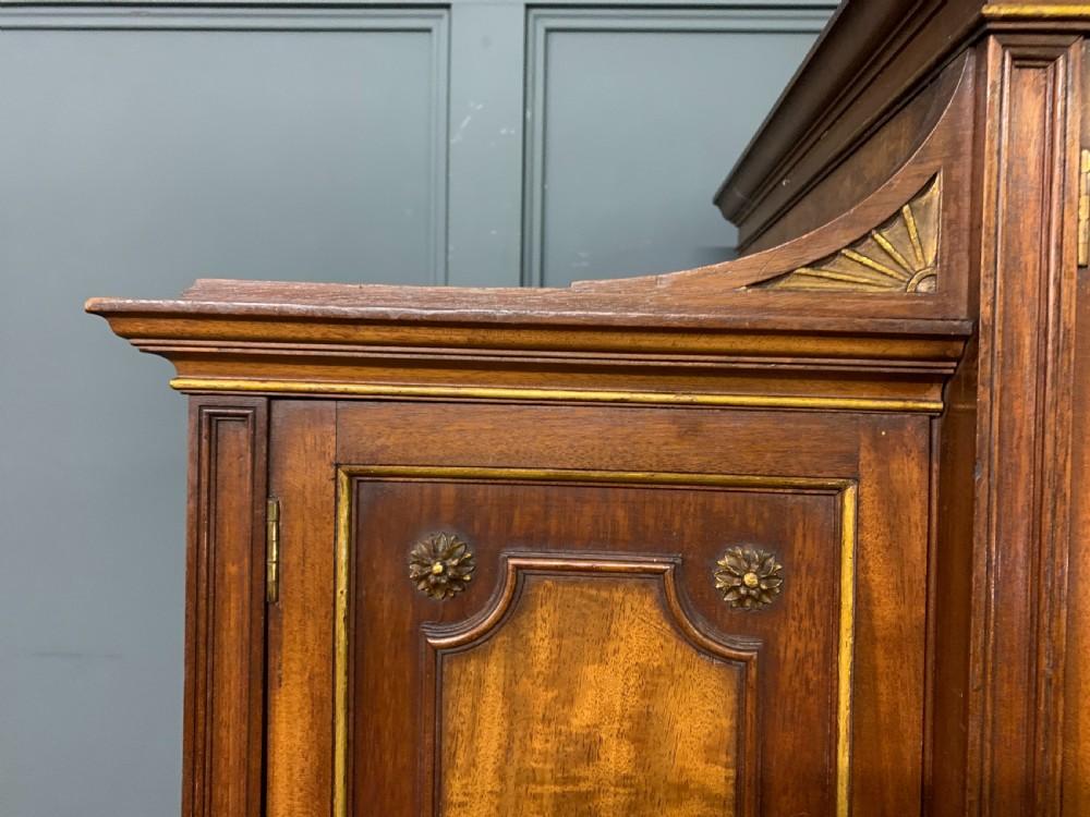 An antique mahogany display cabinet featuring glazed centre doors, side inlaid panels, fluted legs, and an arched top. View XII