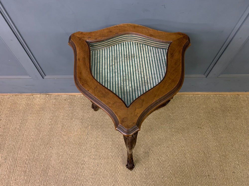 A French carved walnut bijouterie table featuring a trefoil-shaped hinged glass top, cabriole legs, and a striped fabric interior lining. View III