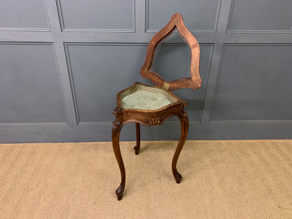 A French carved walnut bijouterie table featuring a trefoil-shaped hinged glass top, cabriole legs, and a striped fabric interior lining. View V