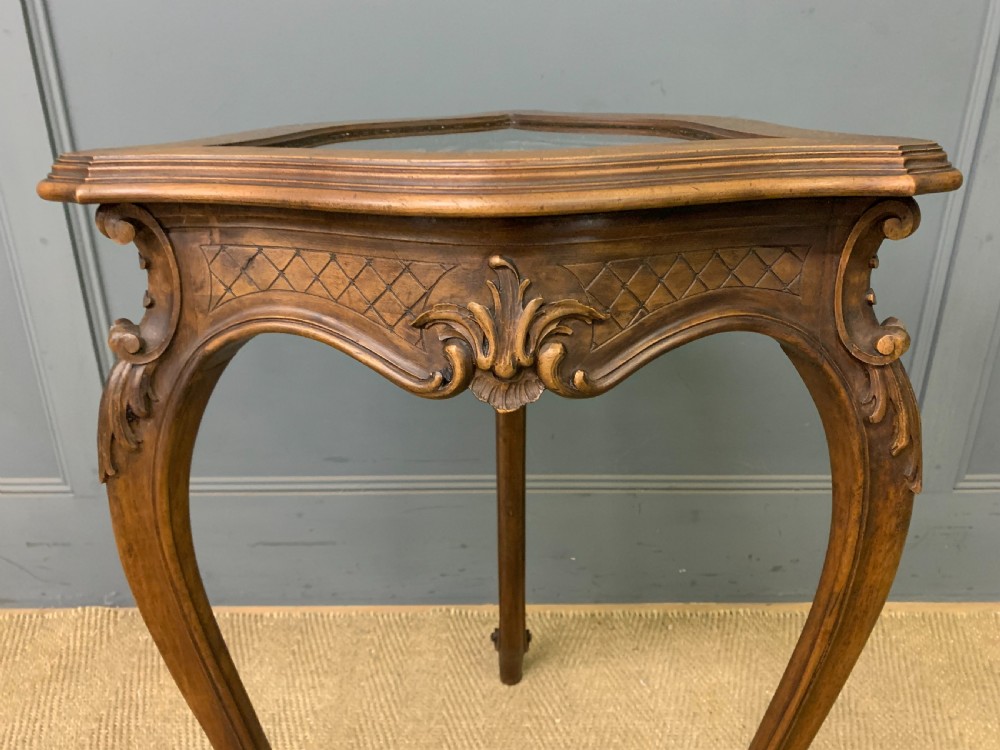 A French carved walnut bijouterie table featuring a trefoil-shaped hinged glass top, cabriole legs, and a striped fabric interior lining. View VII