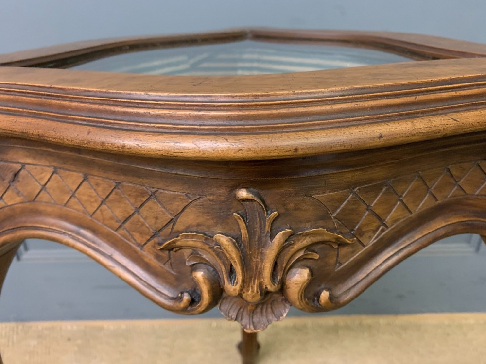A French carved walnut bijouterie table featuring a trefoil-shaped hinged glass top, cabriole legs, and a striped fabric interior lining. View VIII