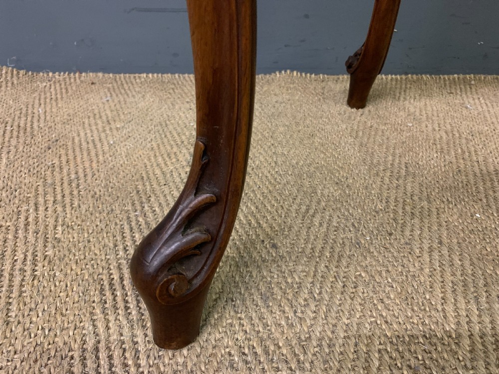 A French carved walnut bijouterie table featuring a trefoil-shaped hinged glass top, cabriole legs, and a striped fabric interior lining. View IX
