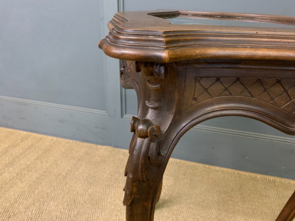 A French carved walnut bijouterie table featuring a trefoil-shaped hinged glass top, cabriole legs, and a striped fabric interior lining. View XI