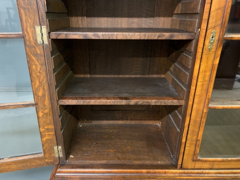 A large three-door burr walnut bookcase with glazed upper doors, three frieze drawers, and crossbanded cupboard doors below. View XIII