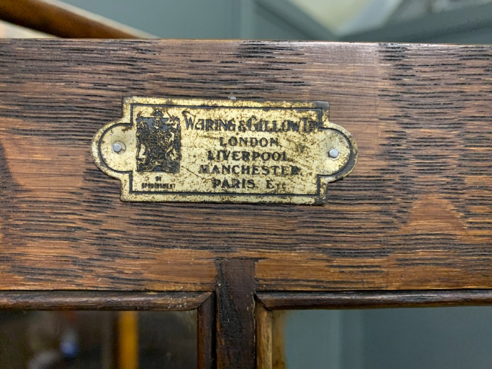 A large three-door burr walnut bookcase with glazed upper doors, three frieze drawers, and crossbanded cupboard doors below. View XIV