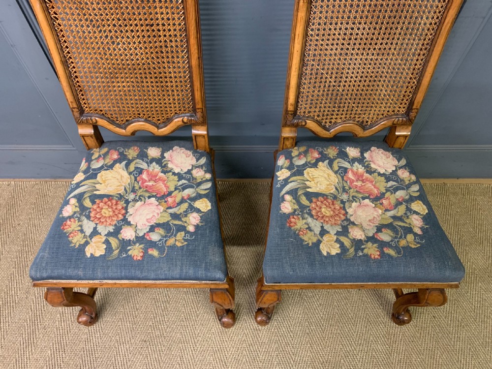A pair of carved walnut side chairs with tall woven cane backs, floral tapestry upholstered seats, and scroll legs. View II