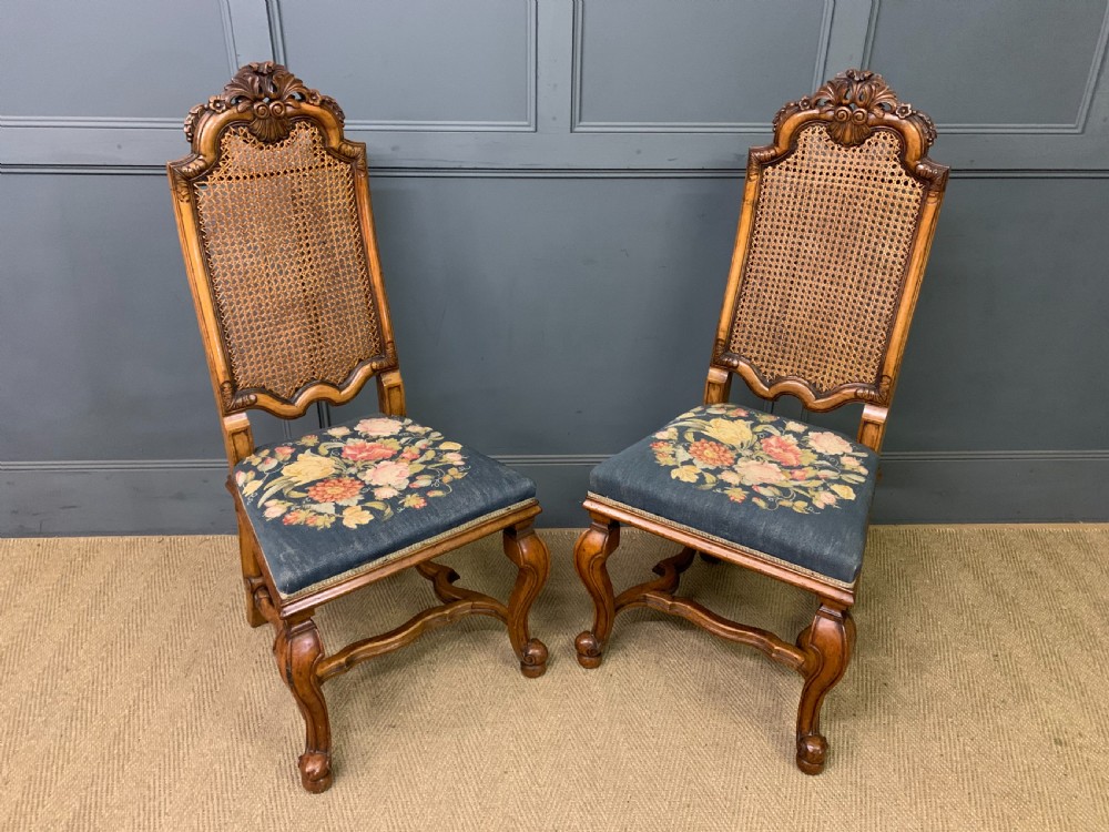 A pair of carved walnut side chairs with tall woven cane backs, floral tapestry upholstered seats, and scroll legs. View III