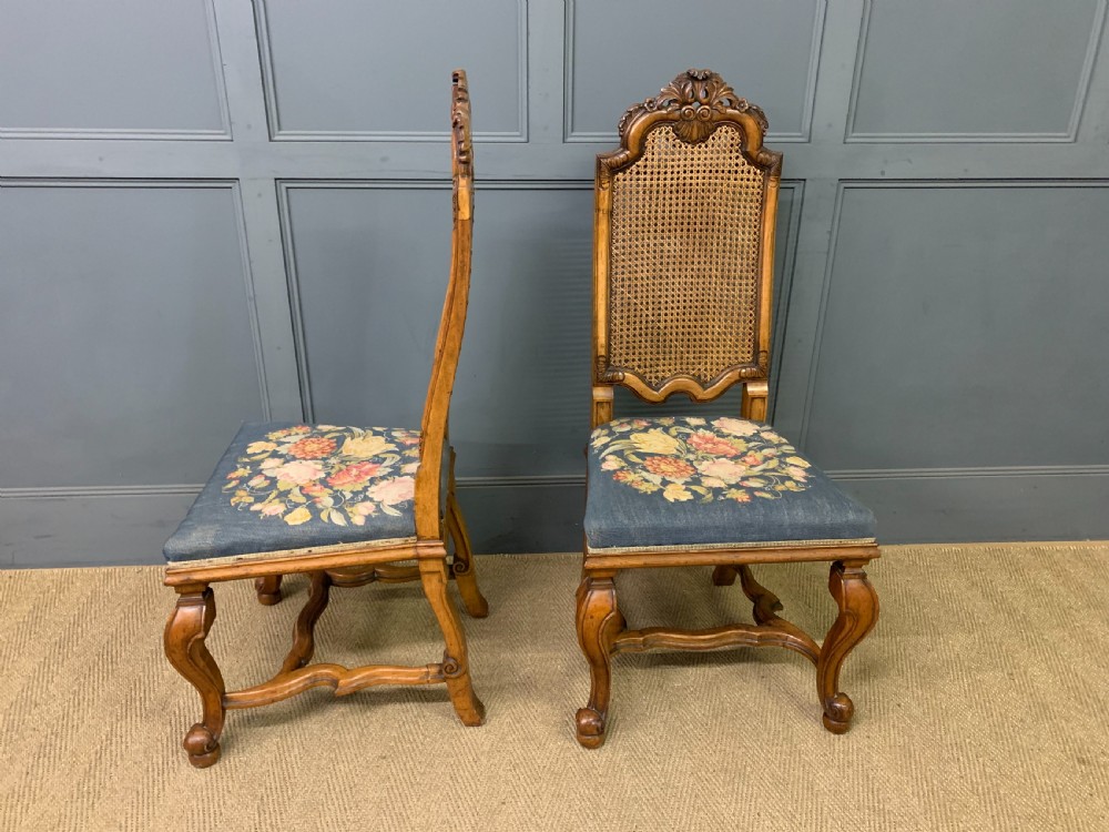 A pair of carved walnut side chairs with tall woven cane backs, floral tapestry upholstered seats, and scroll legs. View IV
