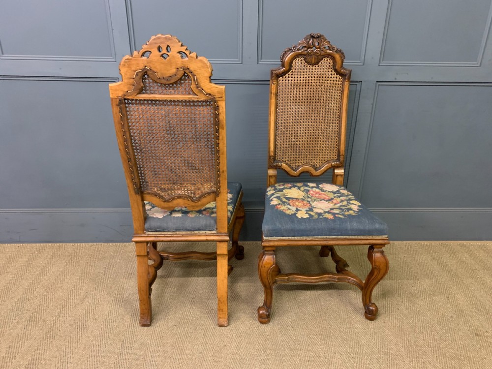 A pair of carved walnut side chairs with tall woven cane backs, floral tapestry upholstered seats, and scroll legs. View V