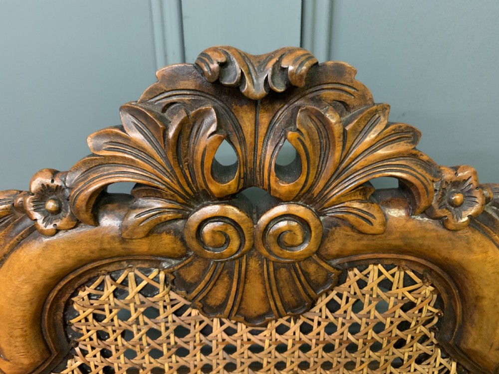 A pair of carved walnut side chairs with tall woven cane backs, floral tapestry upholstered seats, and scroll legs. View VII