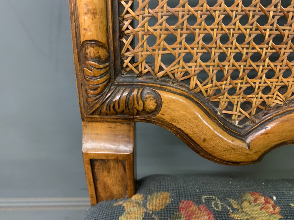 A pair of carved walnut side chairs with tall woven cane backs, floral tapestry upholstered seats, and scroll legs. View IX