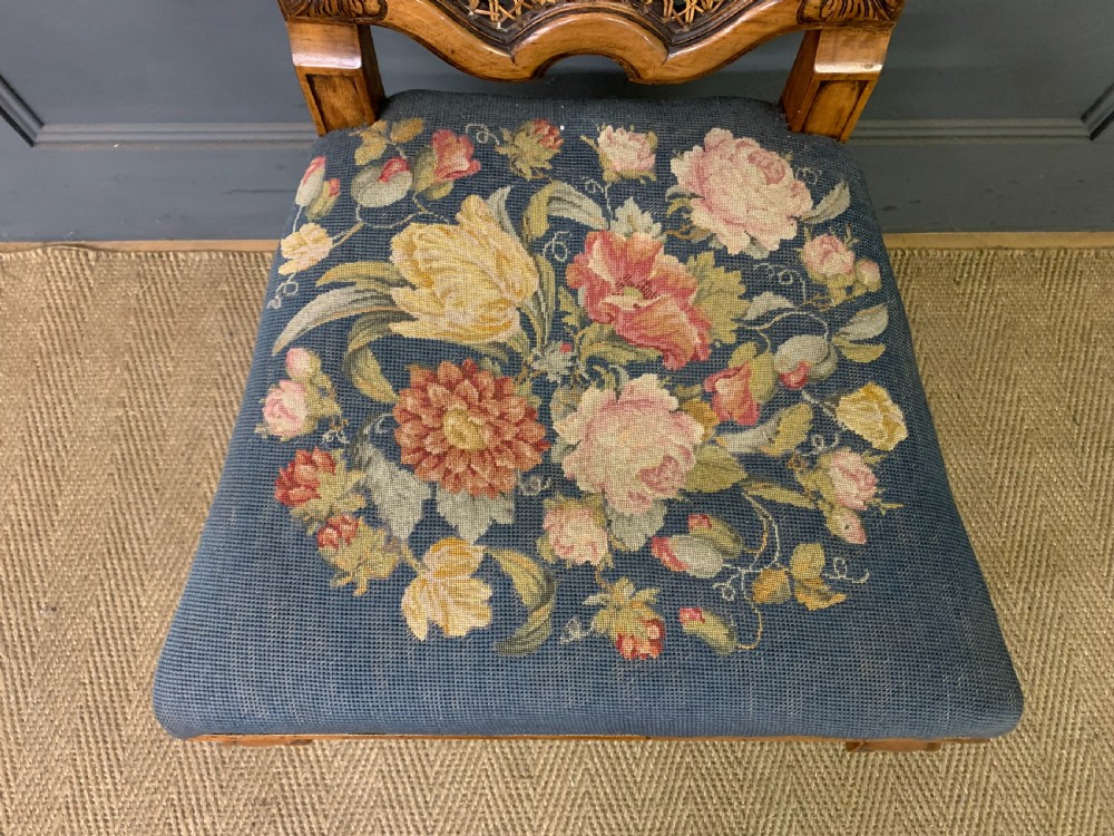 A pair of carved walnut side chairs with tall woven cane backs, floral tapestry upholstered seats, and scroll legs. View XI