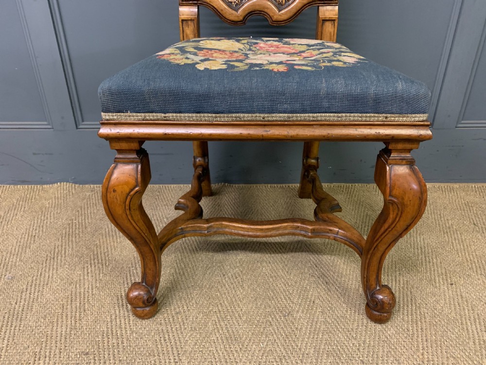 A pair of carved walnut side chairs with tall woven cane backs, floral tapestry upholstered seats, and scroll legs. View XII