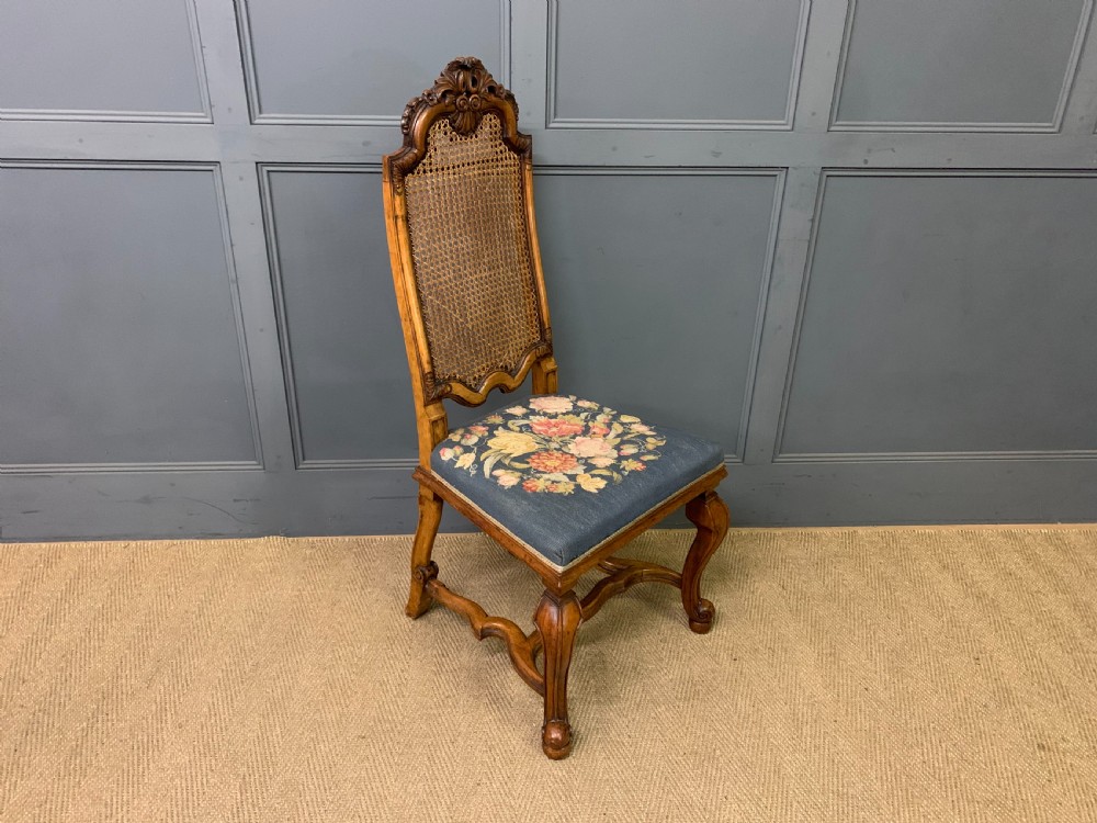 A pair of carved walnut side chairs with tall woven cane backs, floral tapestry upholstered seats, and scroll legs. View XIII
