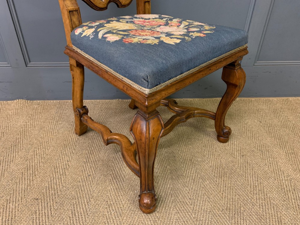 A pair of carved walnut side chairs with tall woven cane backs, floral tapestry upholstered seats, and scroll legs. View XIV