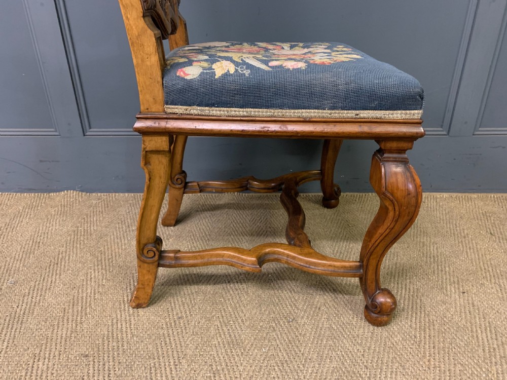 A pair of carved walnut side chairs with tall woven cane backs, floral tapestry upholstered seats, and scroll legs. View XV